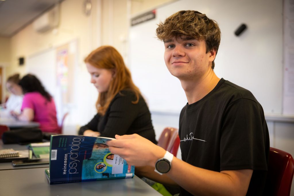 Elizabeth College student with a Psychology textbook in a classroom (2025)